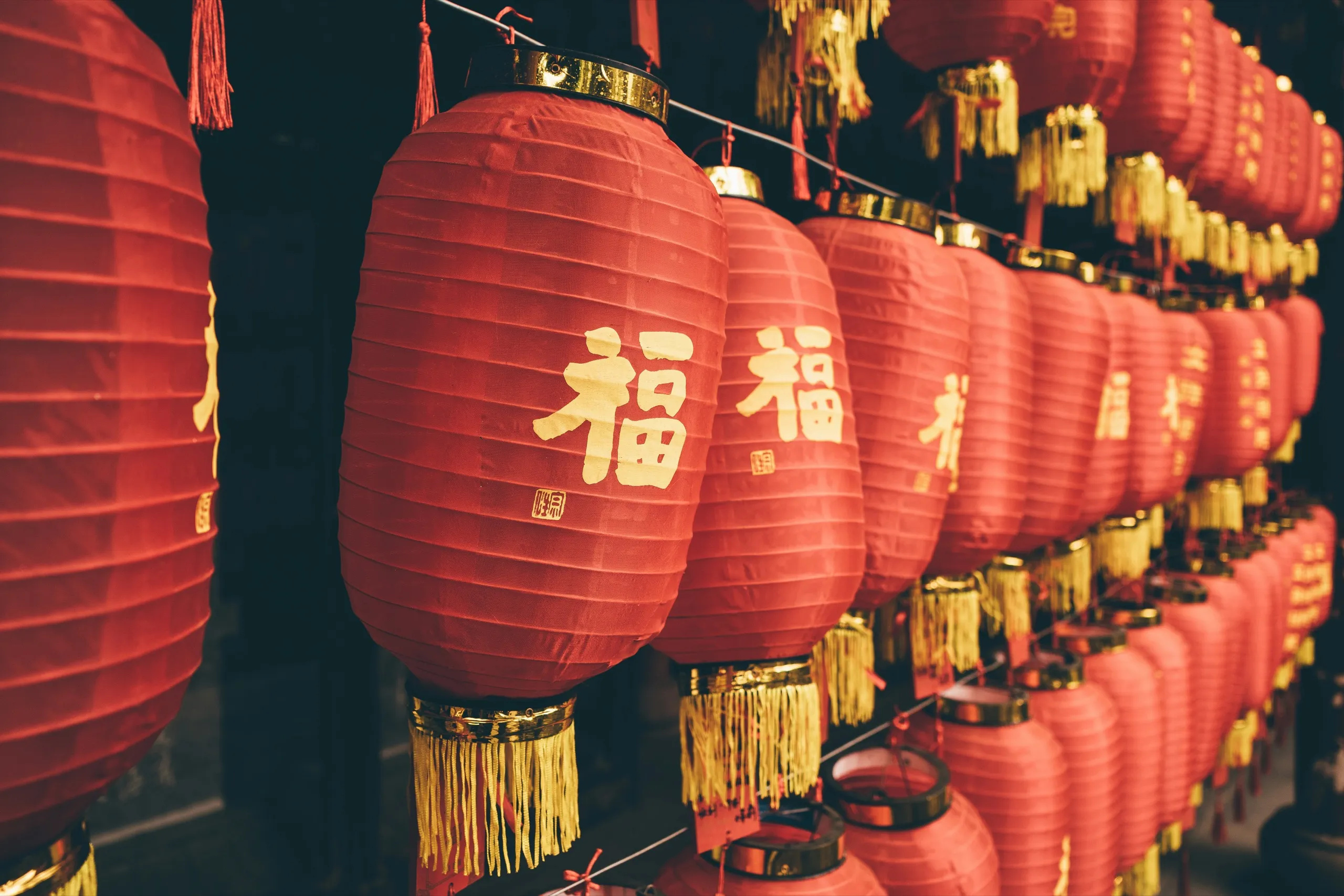 A row of red lanterns printed with the character fu, with gold tassels