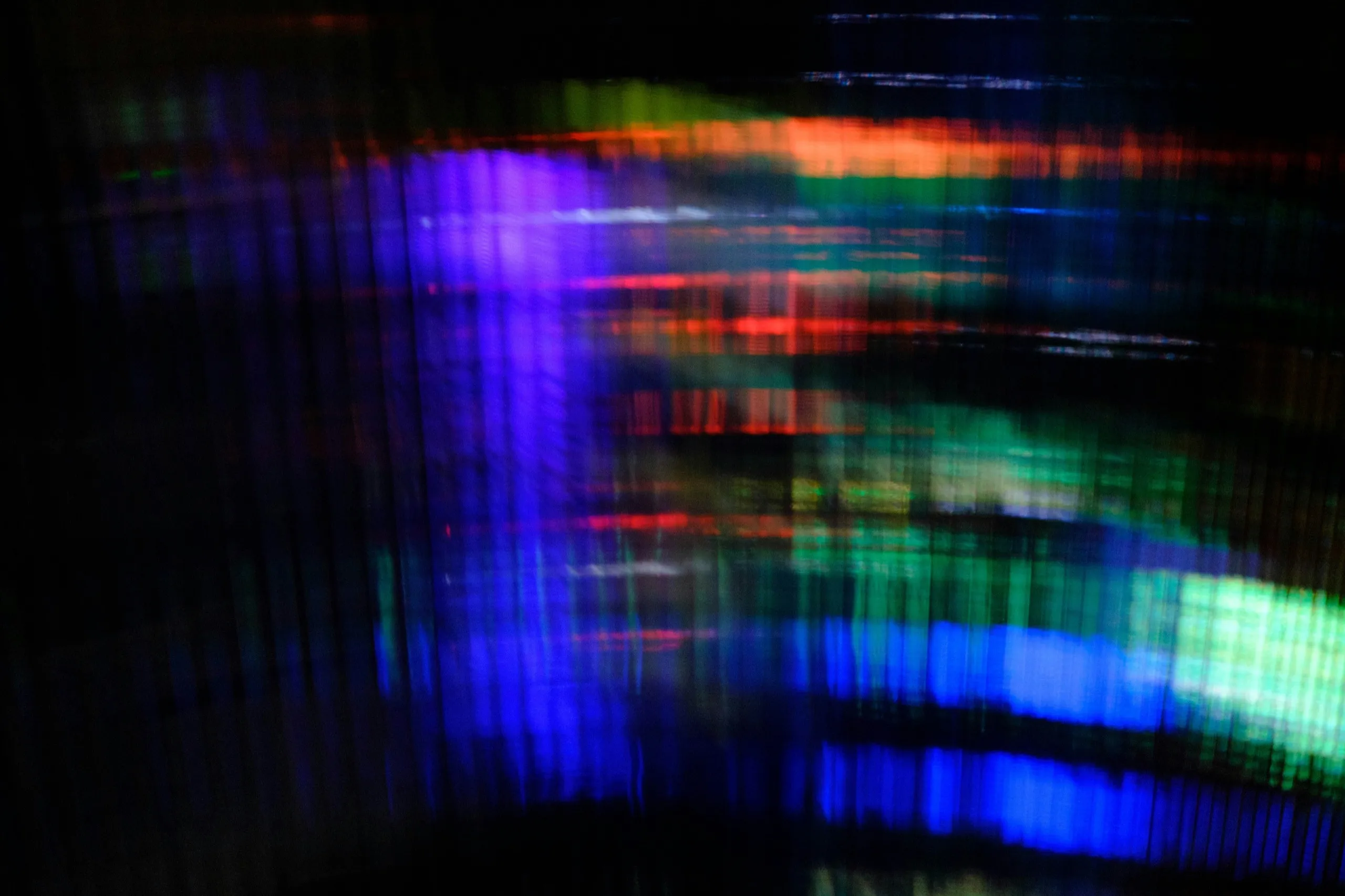 Streaks of blue, green and orange light blurred across a black frame
